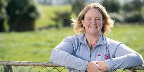 Meridian agribusiness customer Trish Rankin leaning on her fence smiling towards the camera
