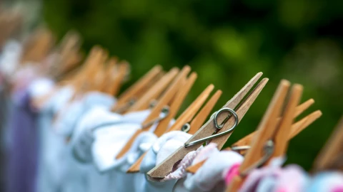 Close up of pegs holding clothing on a washing line.