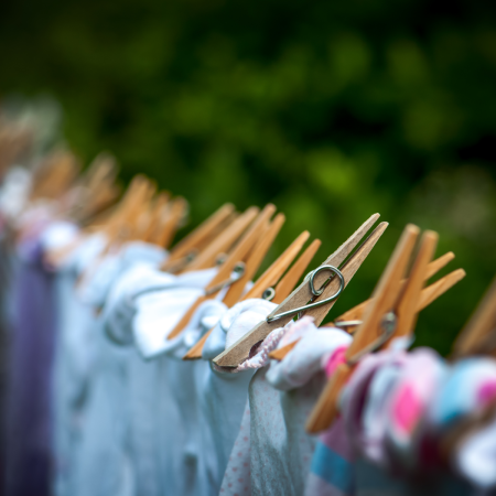 Close up of pegs holding clothing on a washing line.