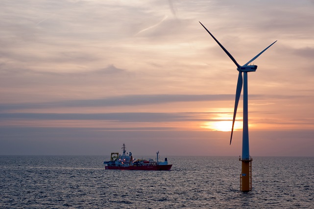 Offshore wind turbine at sunset