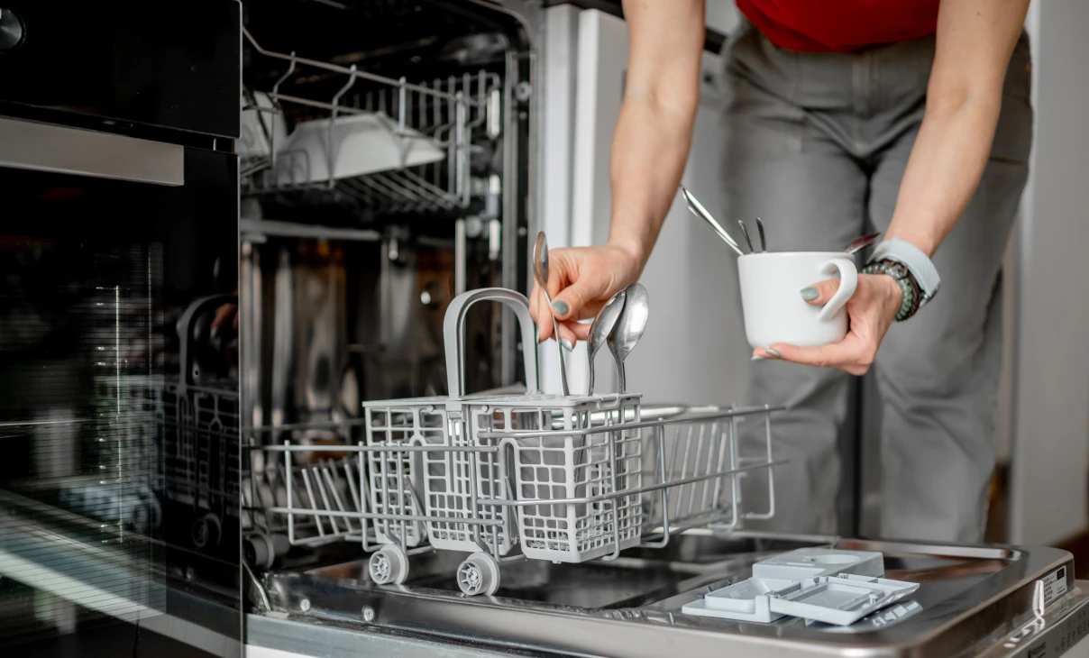 Woman filling dishwasher cutlery tray