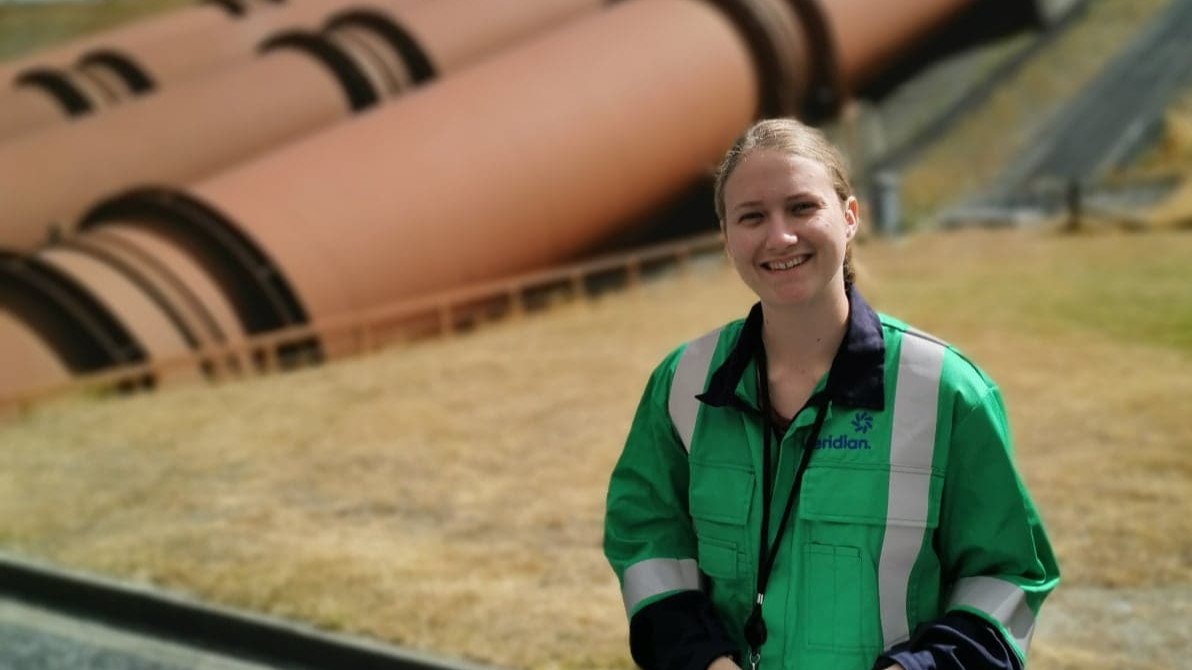 Emily Adams, Product Development Engineer, in front of a power station
