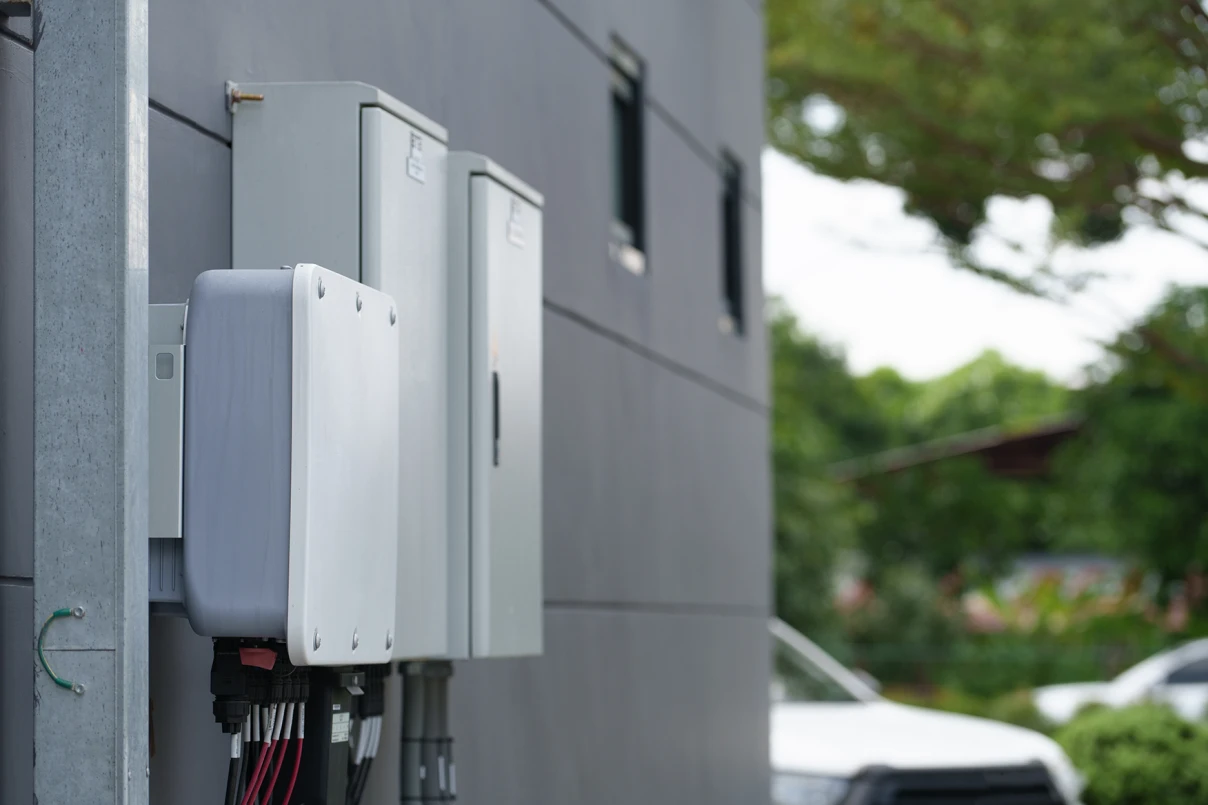 Solar battery and cabinets mounted to the outside wall of a house.