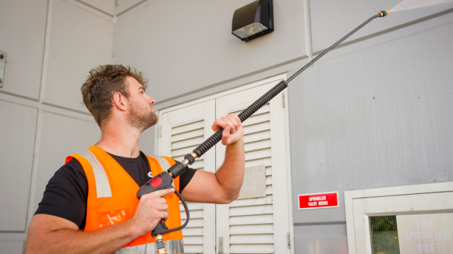 Summit cleaning staff using water blaster