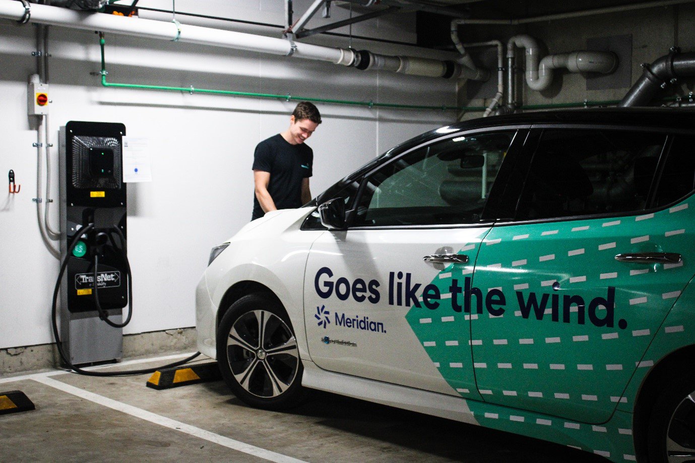 Man plugging his electric car in to a charger