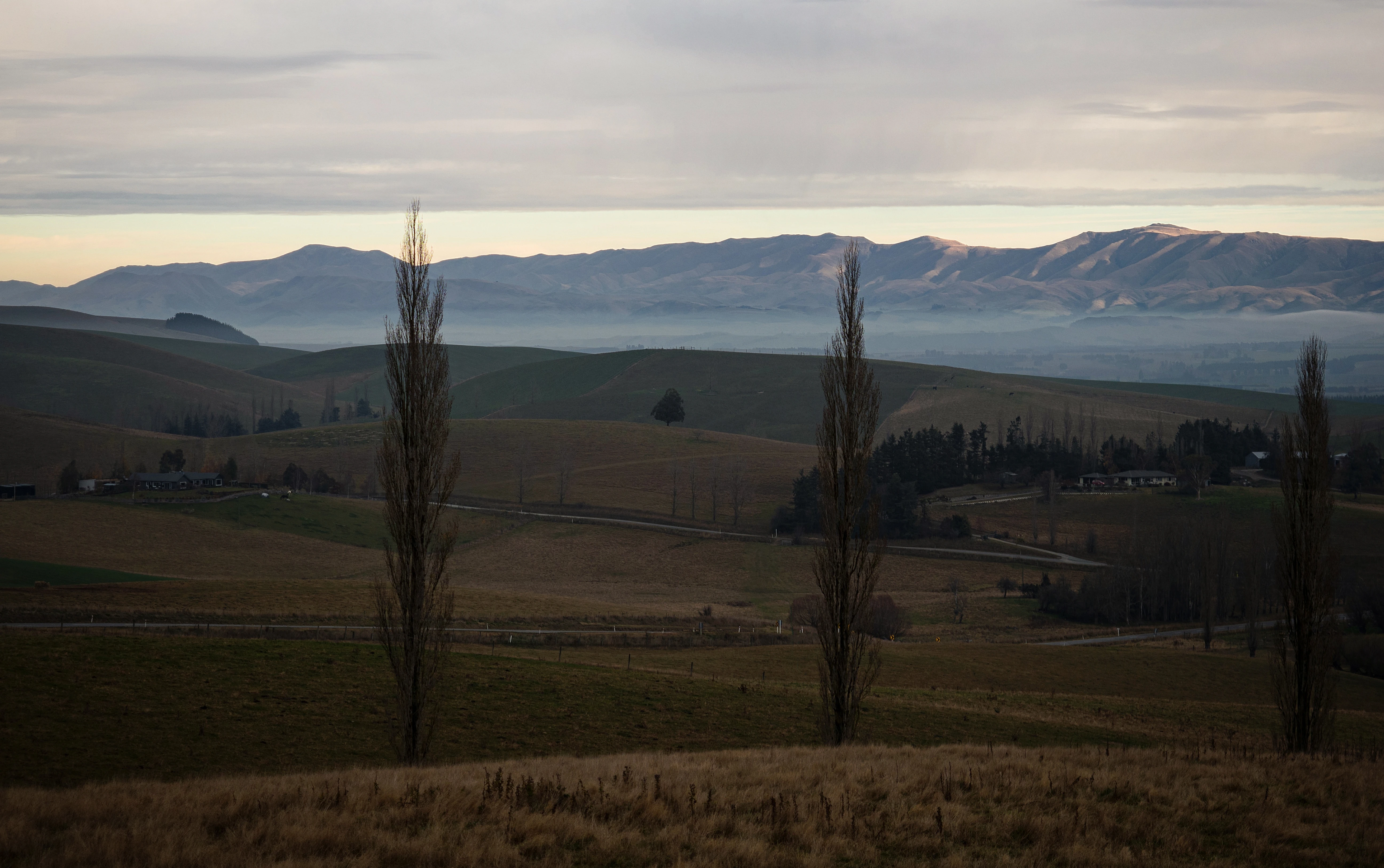 Panorama view of mountain range with low hanging clouds.