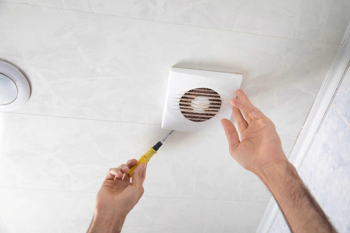 Man installing extraction fan in ceiling